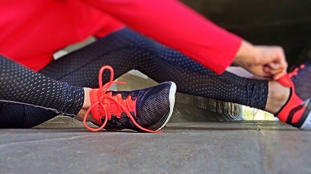 Een vrouw met sportkleding en hardloopschoenen aan.